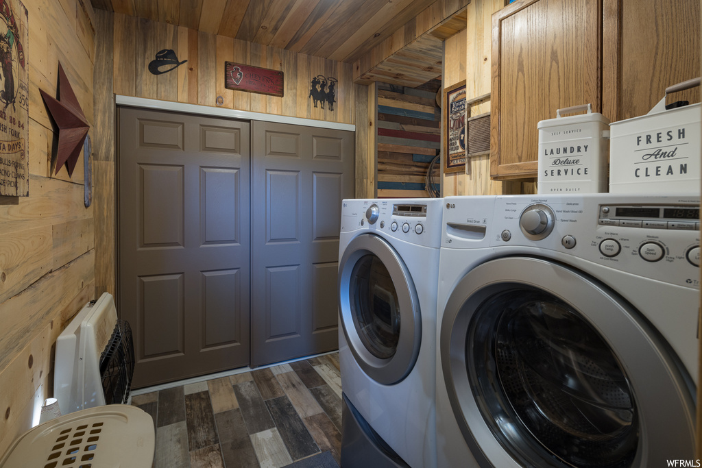Clothes washing area featuring wooden walls, wood ceiling, independent washer and dryer, and dark hardwood flooring