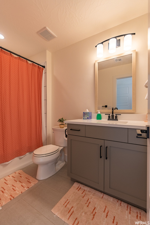 Full bathroom featuring shower / bath combo, vanity, mirror, and light tile floors