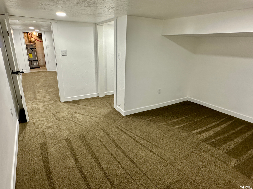 Carpeted empty room with a textured ceiling
