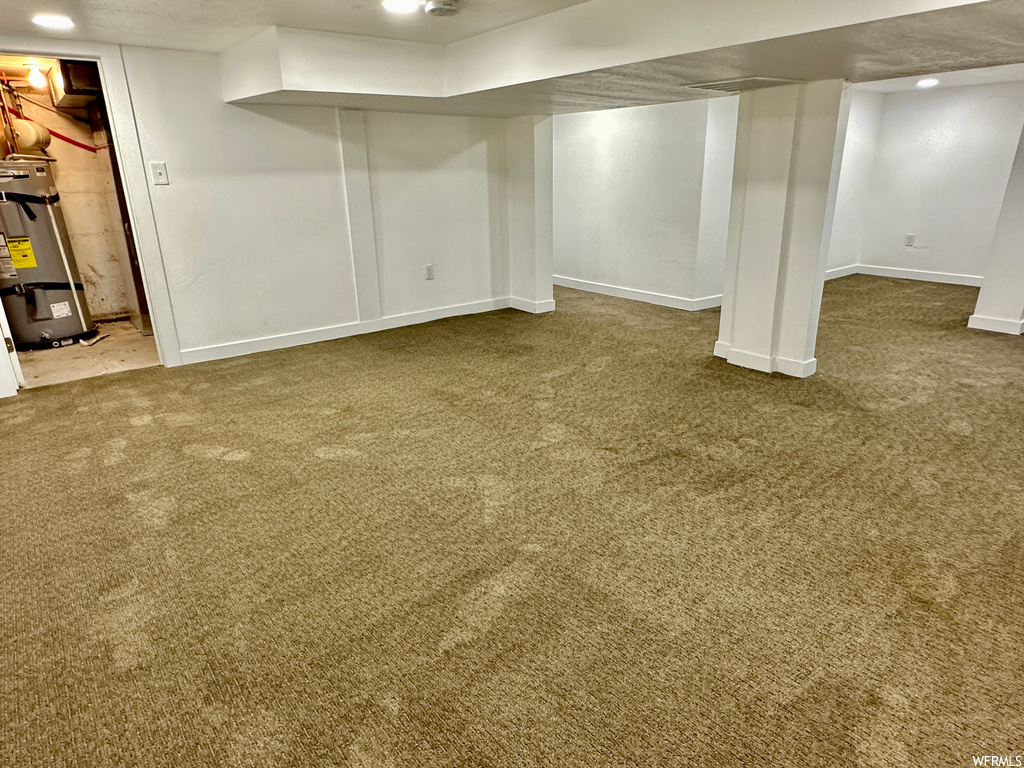 Basement with light carpet and gas water heater