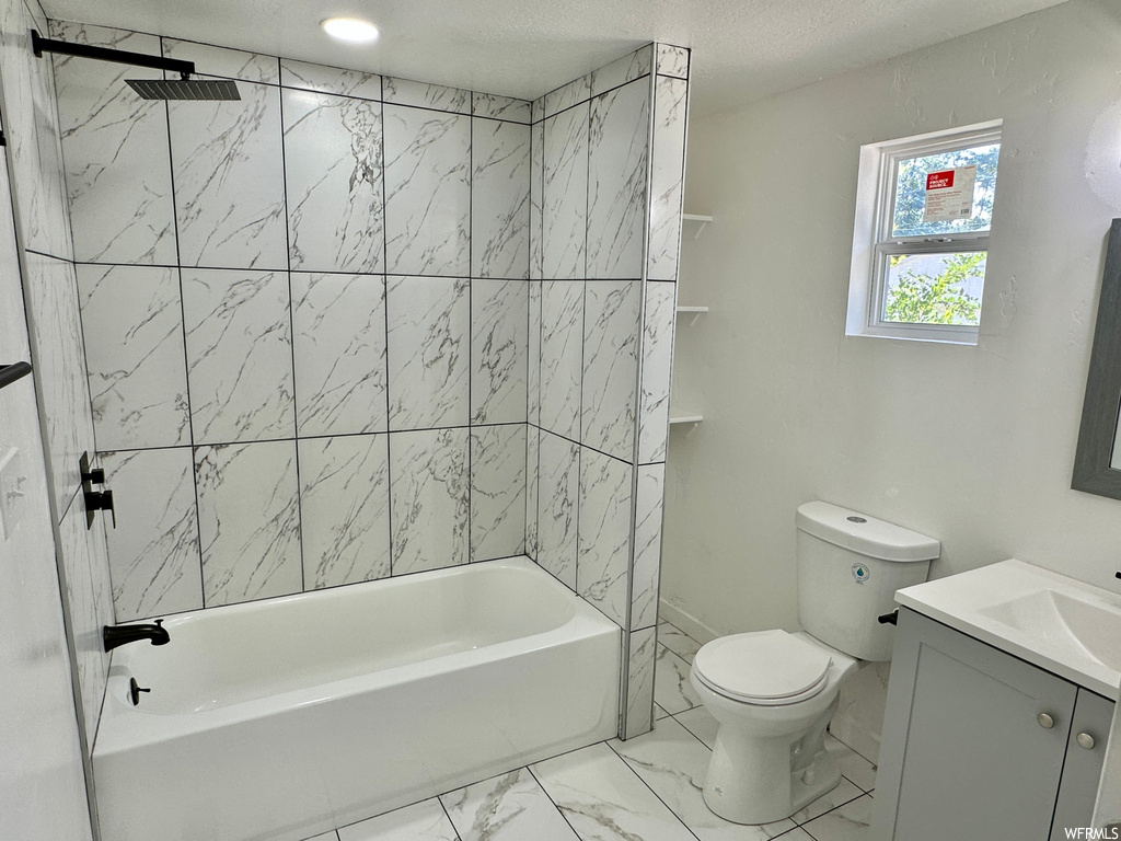Full bathroom with tiled shower / bath combo, vanity, a textured ceiling, and light tile floors