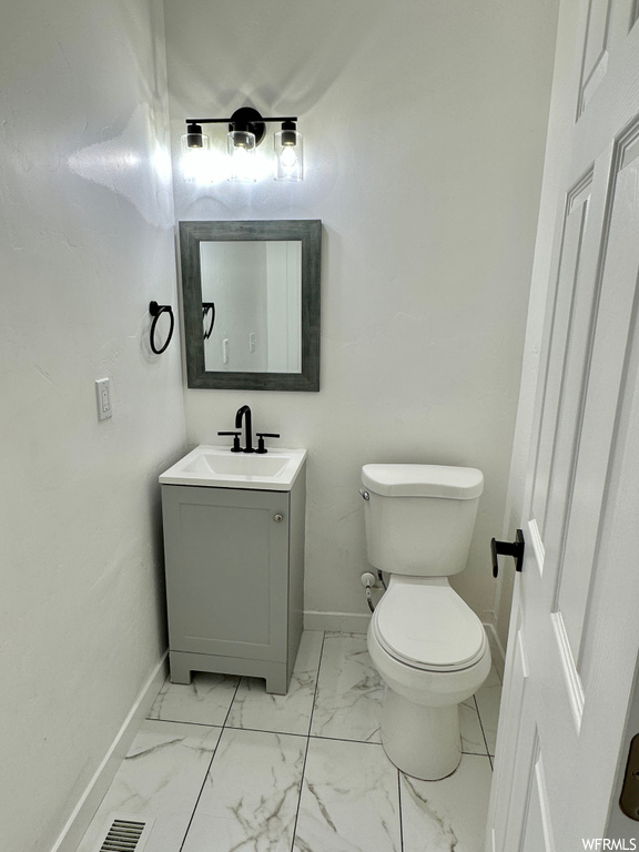 Bathroom featuring large vanity, mirror, and light tile floors