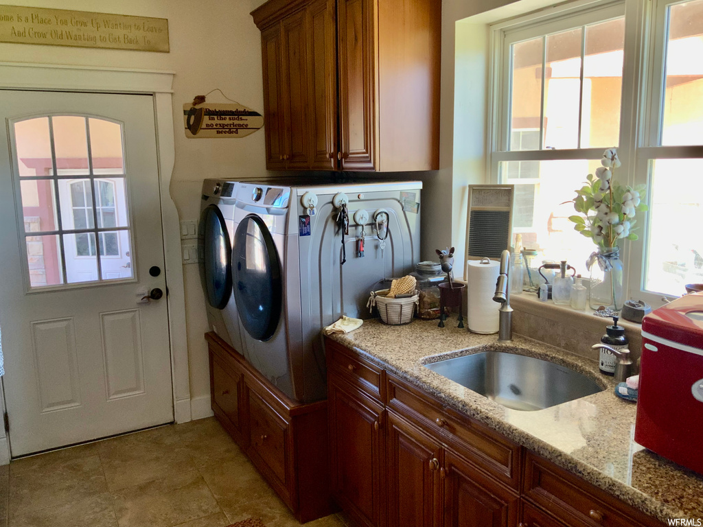 Clothes washing area featuring tile floors and independent washer and dryer
