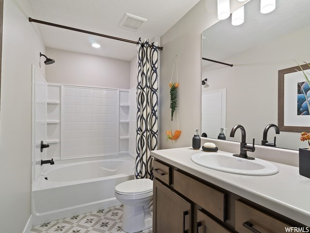 Full bathroom with vanity, mirror, shower / bathtub combination with curtain, and light tile floors