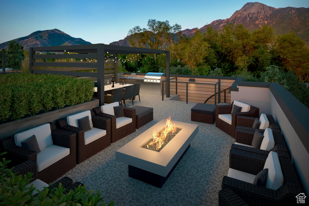 View of patio featuring an outdoor living space with a fire pit and a mountain view