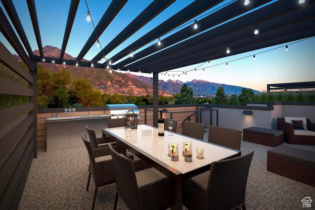 Patio terrace at dusk with a mountain view, area for grilling, outdoor lounge area, and a pergola