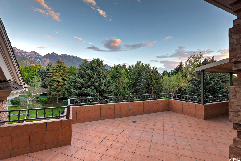 Patio terrace at dusk with balcony and a mountain view