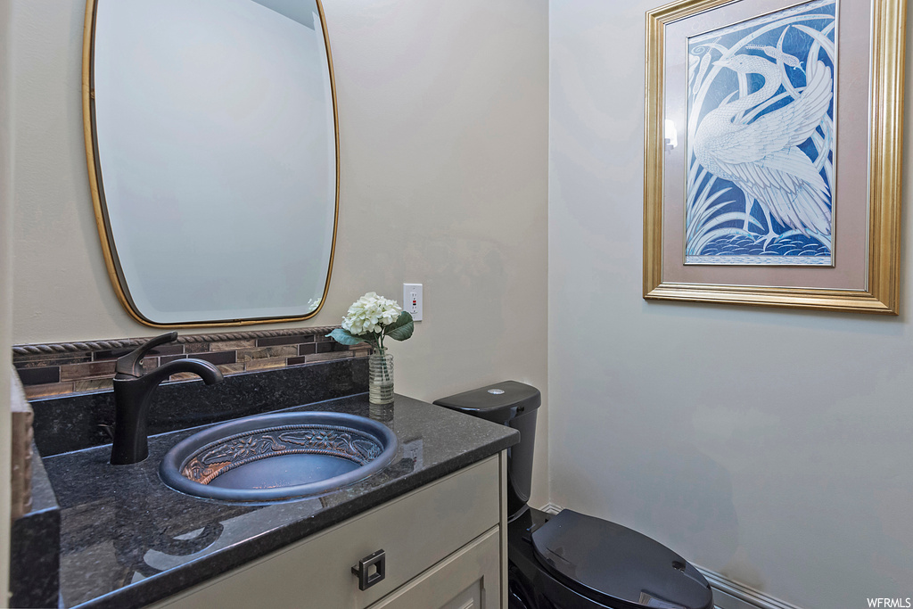 Bathroom with vanity, backsplash, and mirror