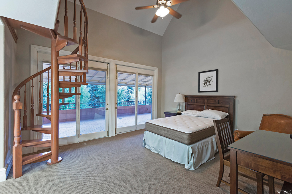 Bedroom featuring ceiling fan, a high ceiling, light carpet, and lofted ceiling