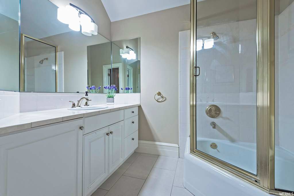Bathroom featuring vanity, combined bath / shower with glass door, mirror, and light tile floors