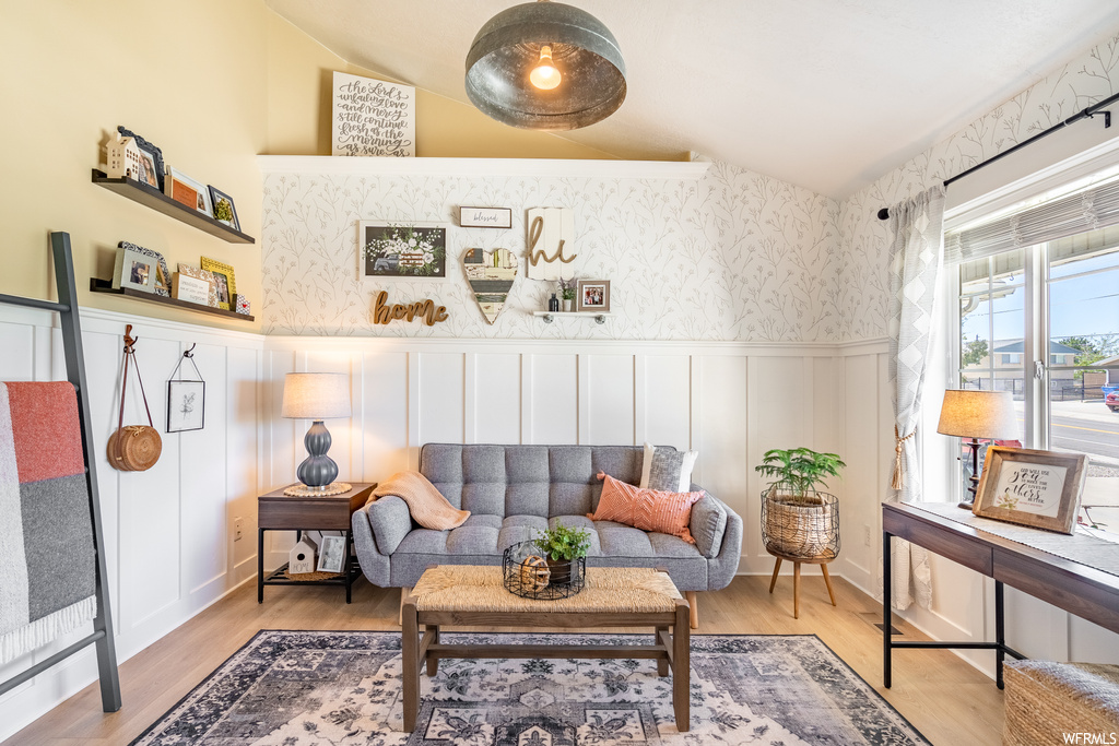 Hardwood floored living room featuring vaulted ceiling