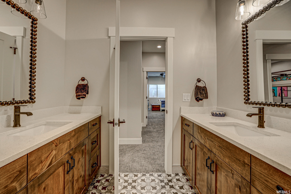 Bathroom with dual large vanity, mirror, and light tile floors