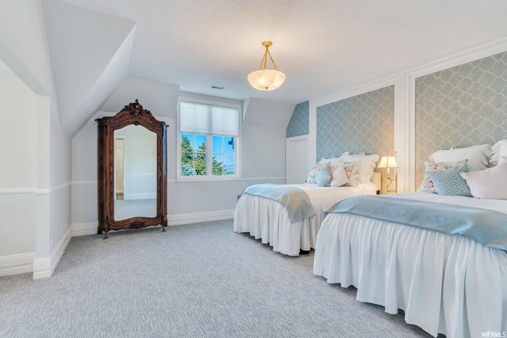 Bedroom featuring light carpet and lofted ceiling