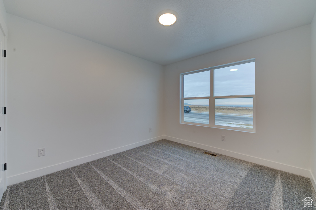 Spare room with a water view and carpet flooring