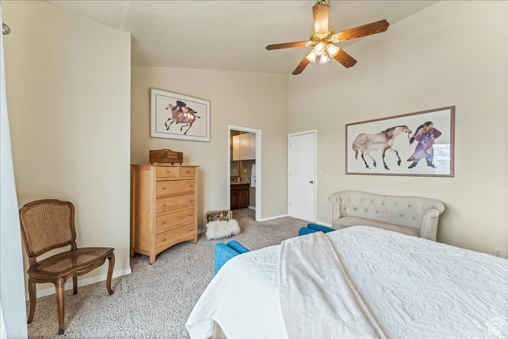 Bedroom with a closet, light carpet, ceiling fan, and vaulted ceiling