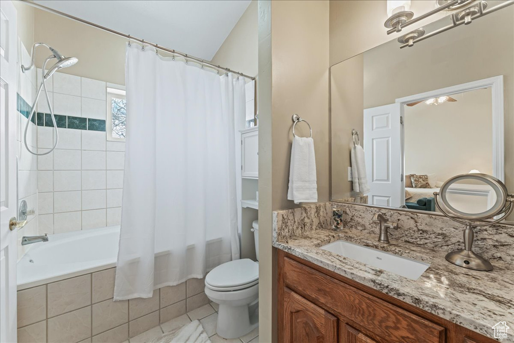 Full bathroom featuring tile floors, shower / bath combination with curtain, vanity, and toilet