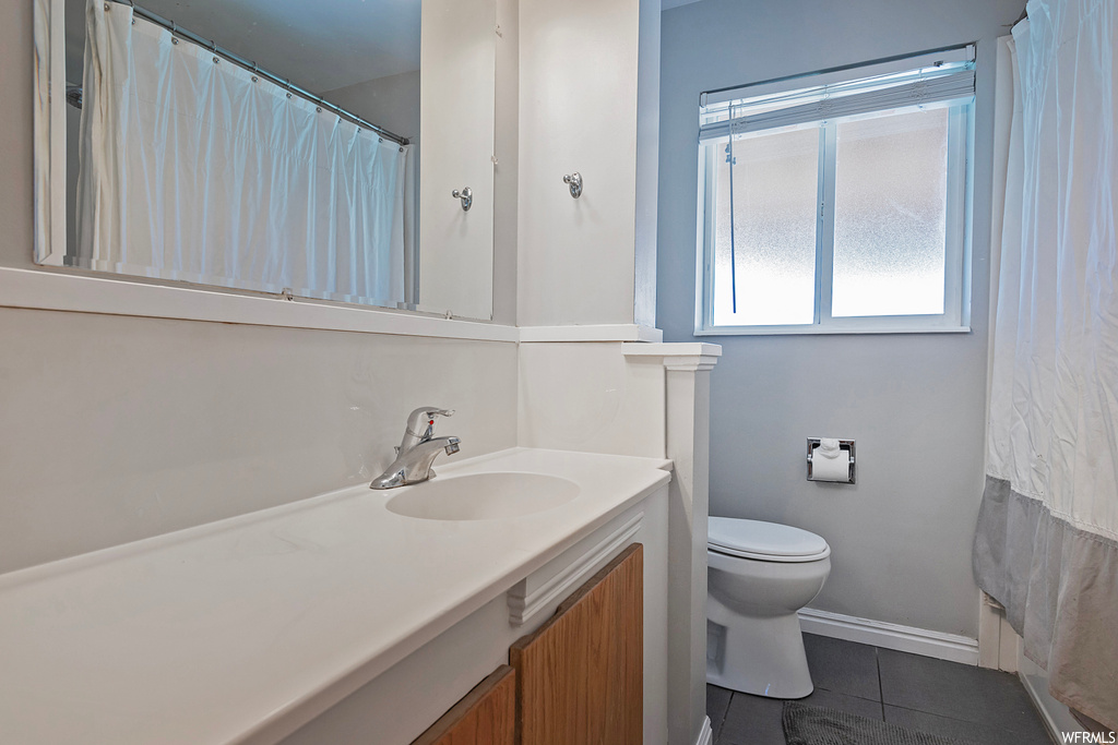 Bathroom featuring tile flooring, vanity with extensive cabinet space, and mirror