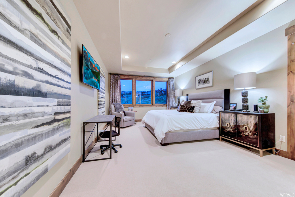 Carpeted bedroom with a tray ceiling