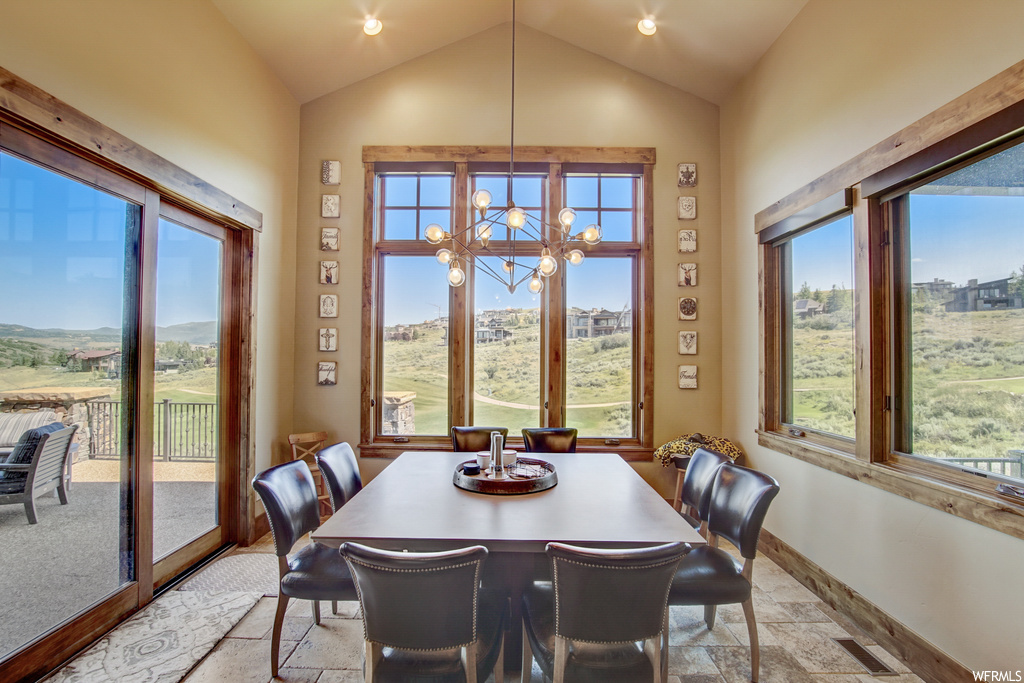 Carpeted dining room featuring plenty of natural light, vaulted ceiling, and a high ceiling