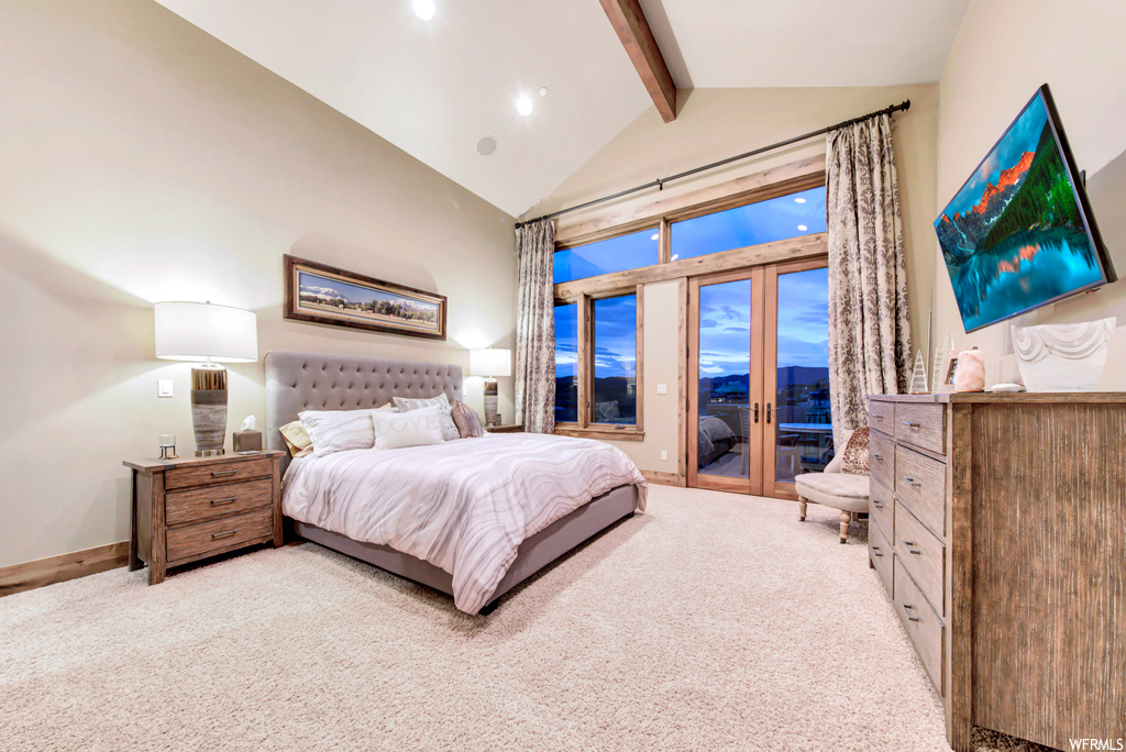 Bedroom with lofted ceiling with beams, french doors, and light carpet