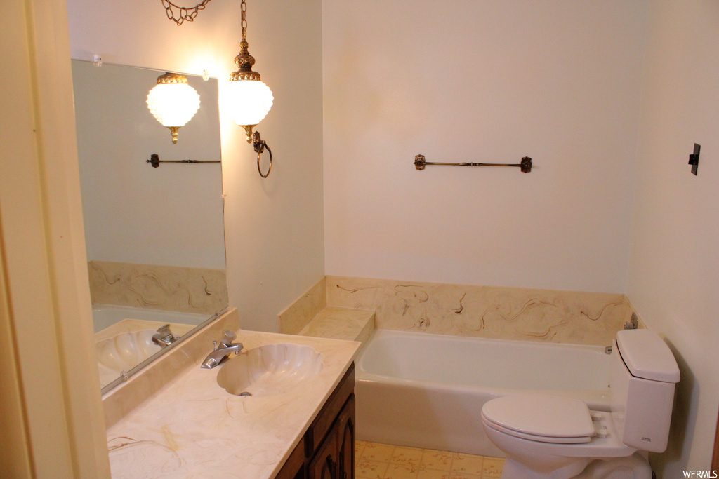 Bathroom featuring large vanity, a bathtub, mirror, and light tile floors