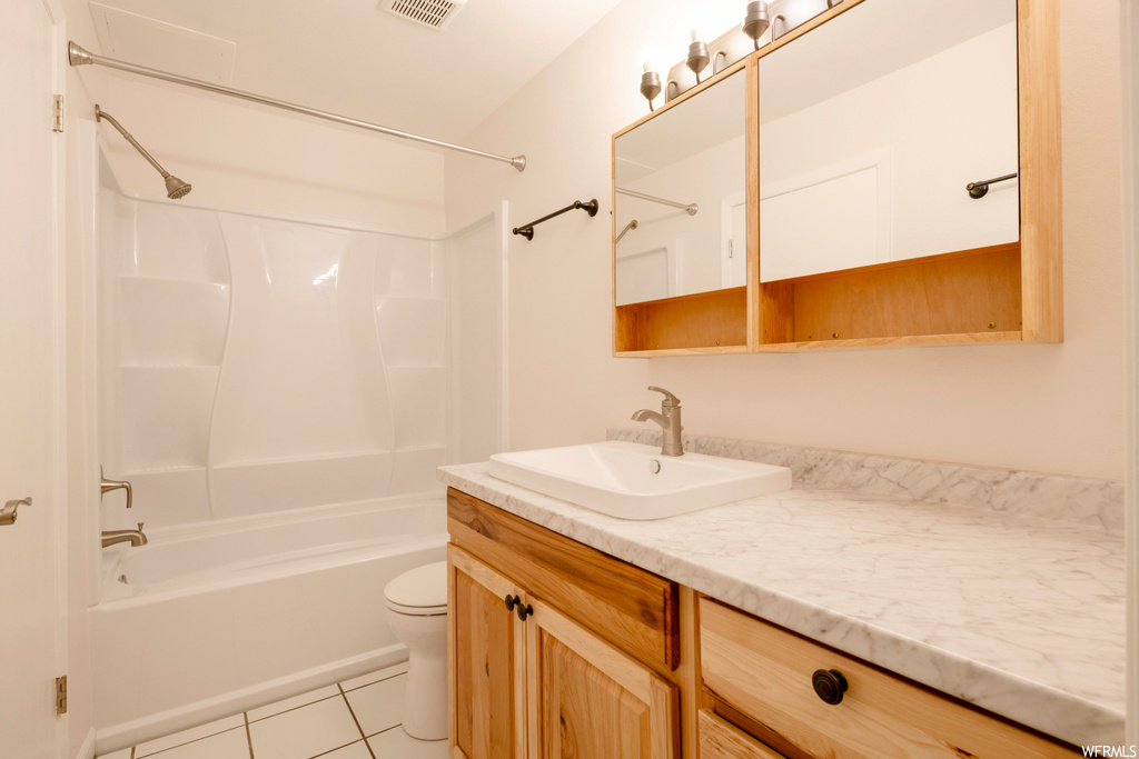 Full bathroom with shower / bathing tub combination, vanity, mirror, and light tile floors