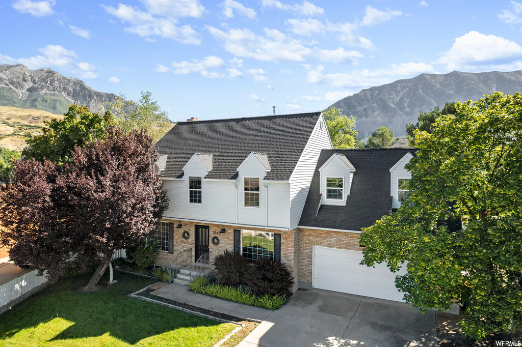 View of front of property featuring garage, a front yard, and a mountain view