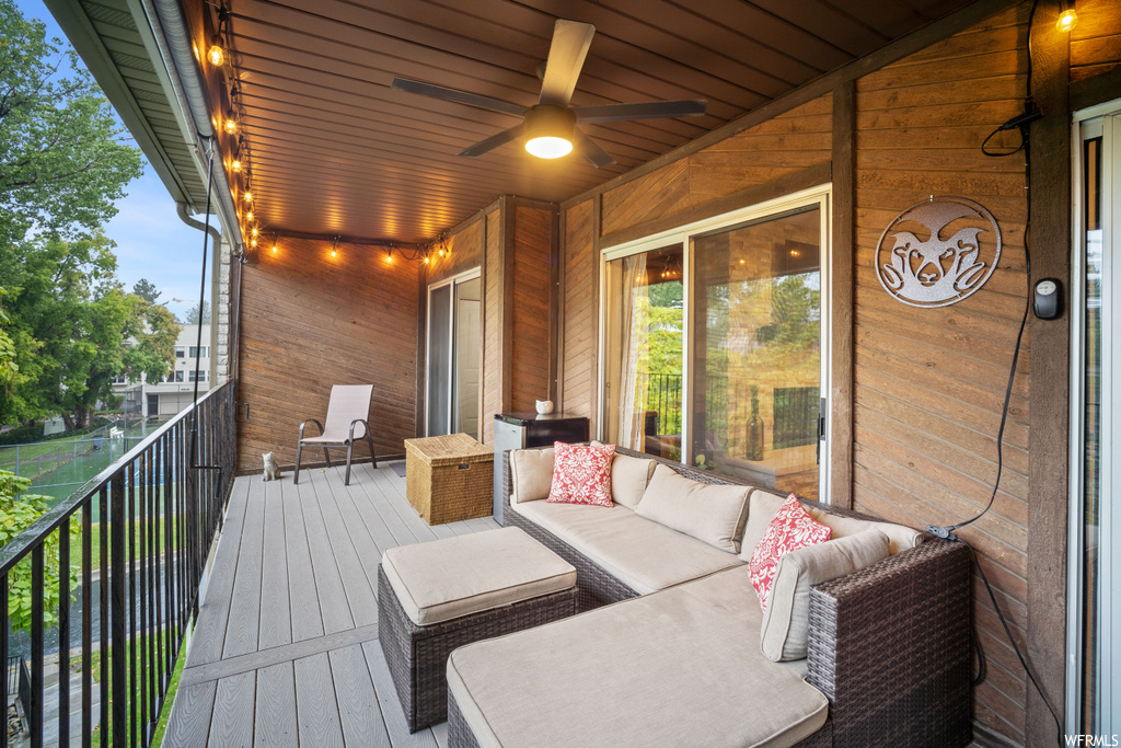 Wooden deck featuring ceiling fan and outdoor lounge area