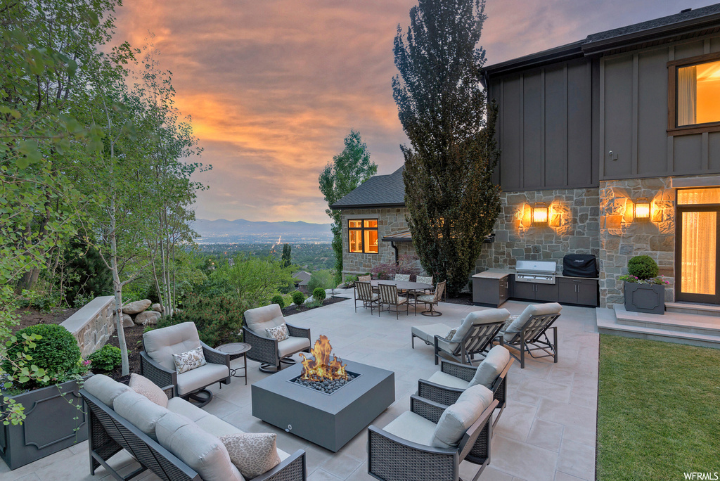 Patio terrace at dusk featuring an outdoor living space with a fire pit