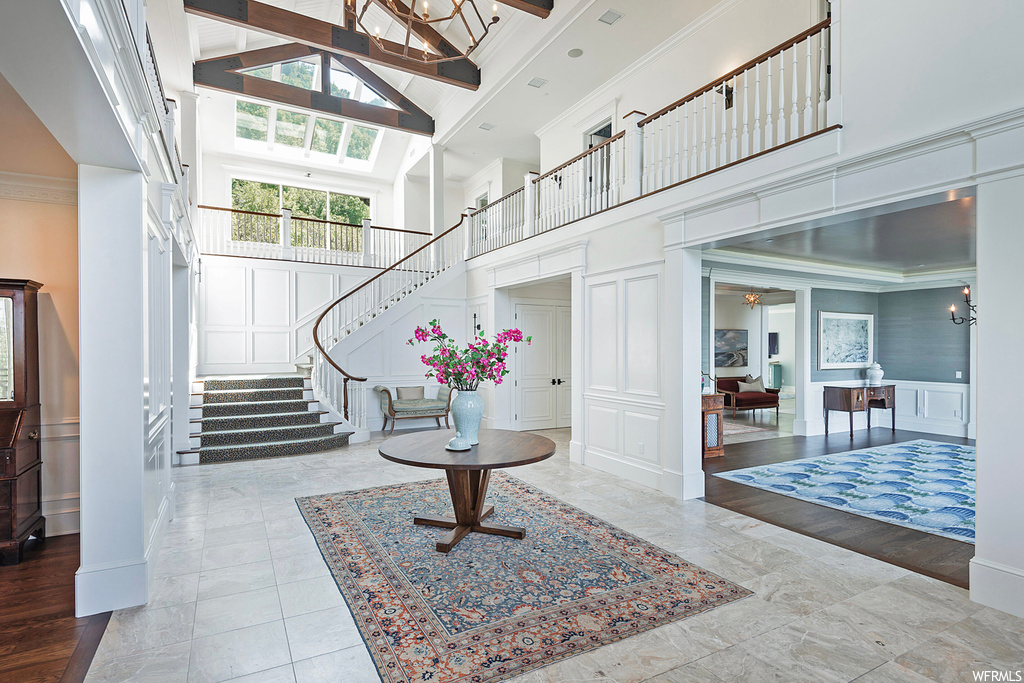 Foyer featuring ornamental molding, a high ceiling, and light tile floors