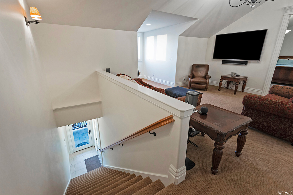 Stairway with lofted ceiling and carpet flooring