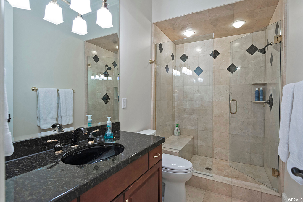 Bathroom with a shower with door, a skylight, oversized vanity, light tile flooring, and mirror