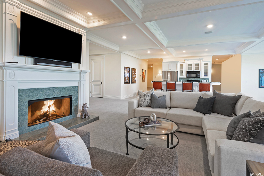 Carpeted living room featuring crown molding, coffered ceiling, beam ceiling, and a fireplace