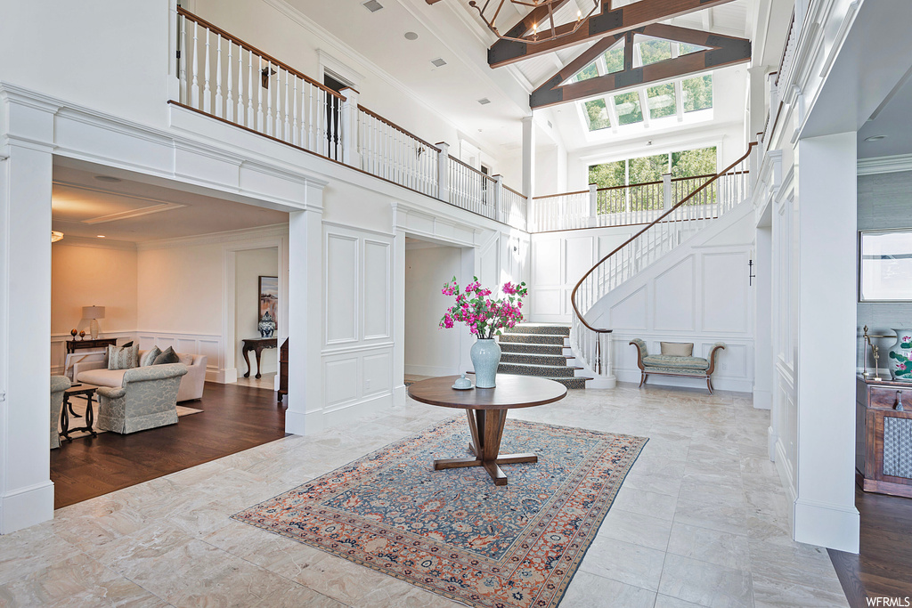 Interior space featuring ornamental molding, a high ceiling, and light tile floors