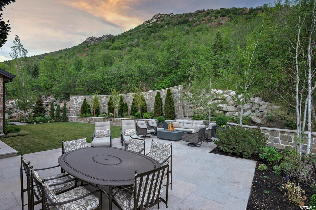 Patio terrace at dusk with an outdoor living space and a mountain view