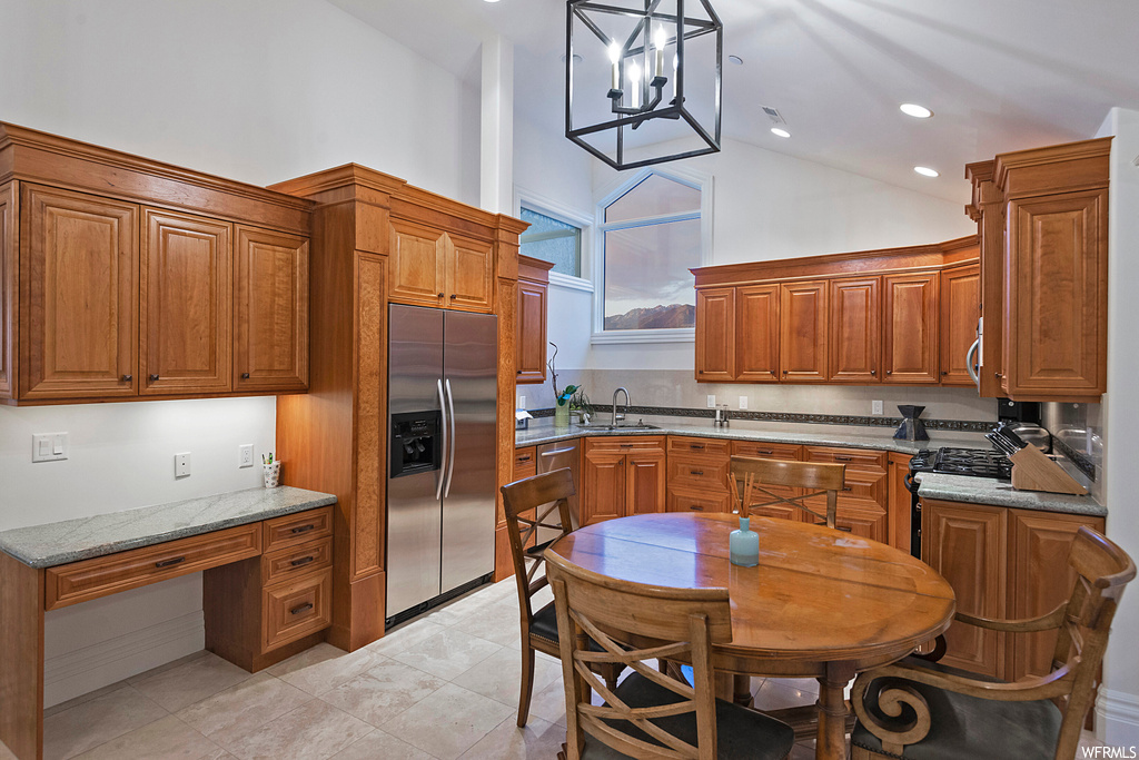Kitchen featuring range, brown cabinets, light tile floors, lofted ceiling, and stainless steel fridge with ice dispenser