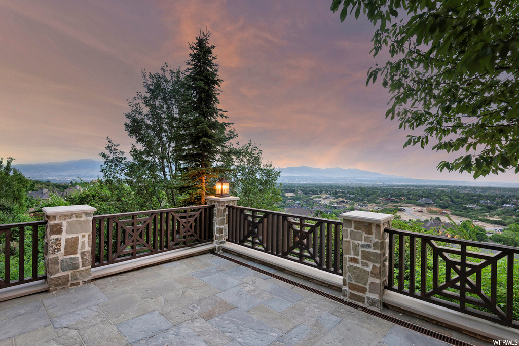 Patio terrace at dusk featuring a mountain view