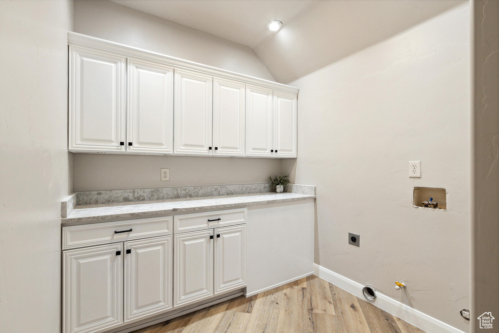 Laundry room with electric dryer hookup, cabinets, gas dryer hookup, light hardwood / wood-style flooring, and washer hookup