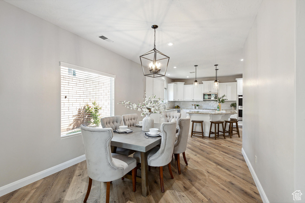 Dining space featuring a chandelier and light hardwood / wood-style floors