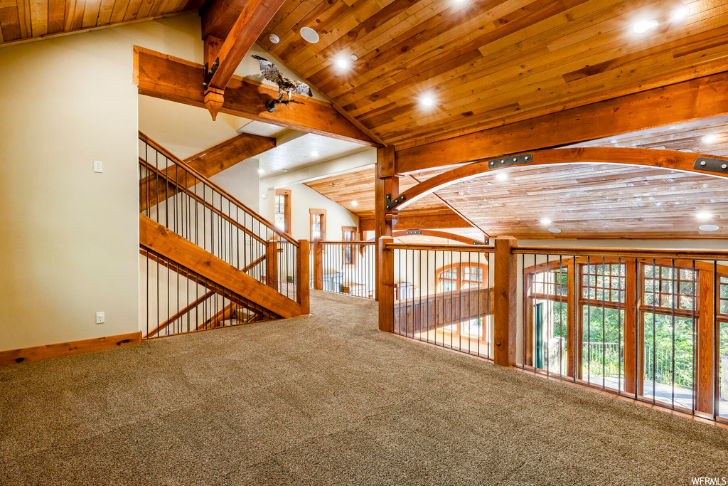 Hallway with carpet floors, wood ceiling, and lofted ceiling