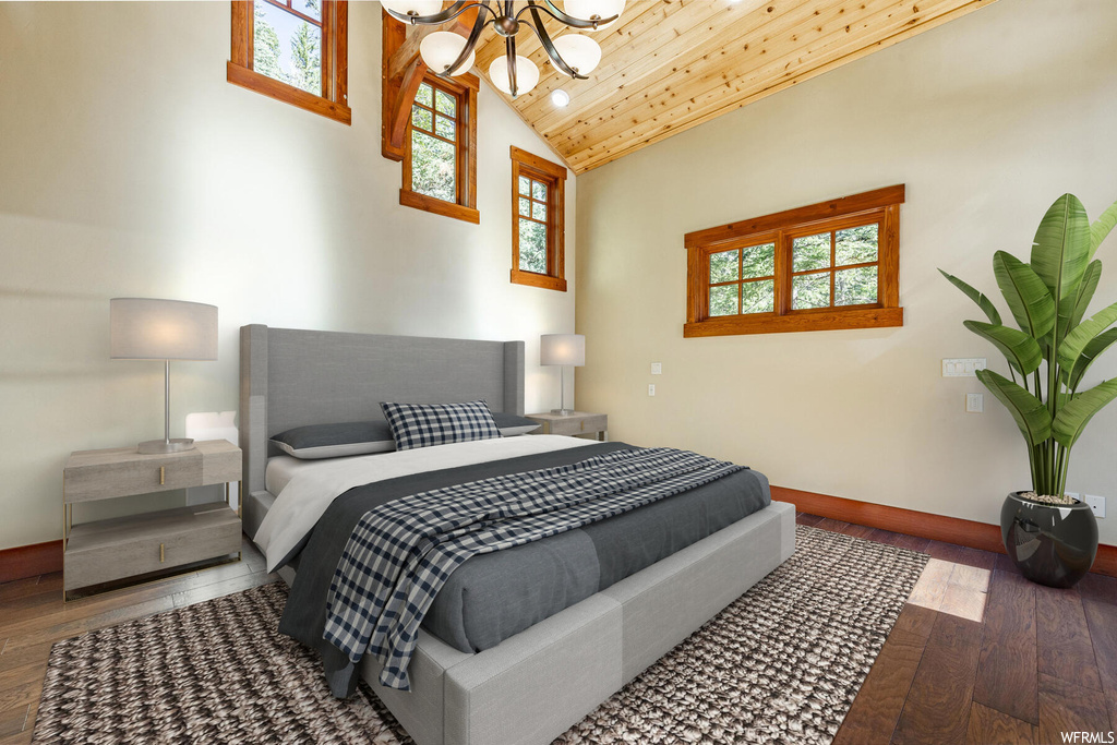 Hardwood floored bedroom with a chandelier, multiple windows, wood ceiling, vaulted ceiling, and a high ceiling