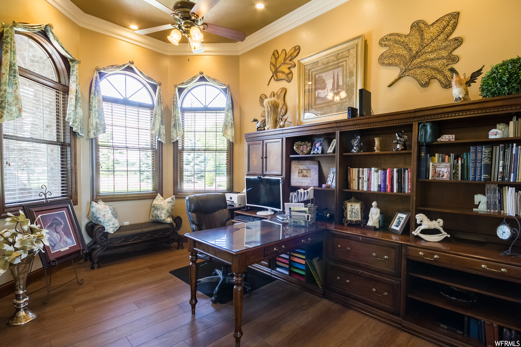 Wood floored office featuring ornamental molding and ceiling fan