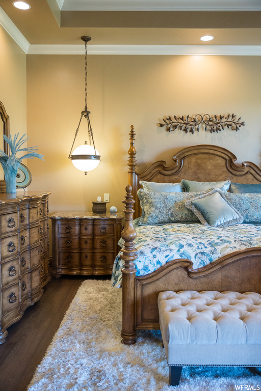 Hardwood floored bedroom featuring ornamental molding