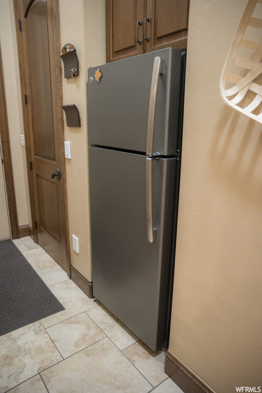 Kitchen featuring stainless steel fridge and light tile floors