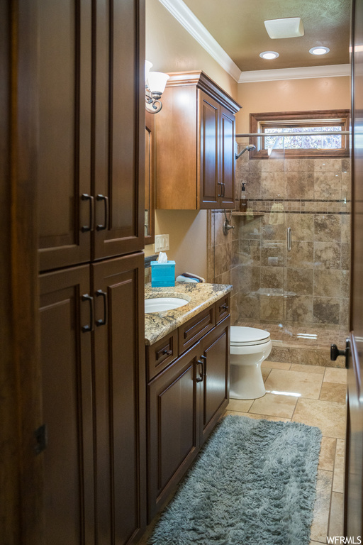 Bathroom featuring an enclosed shower, ornamental molding, tile flooring, and vanity