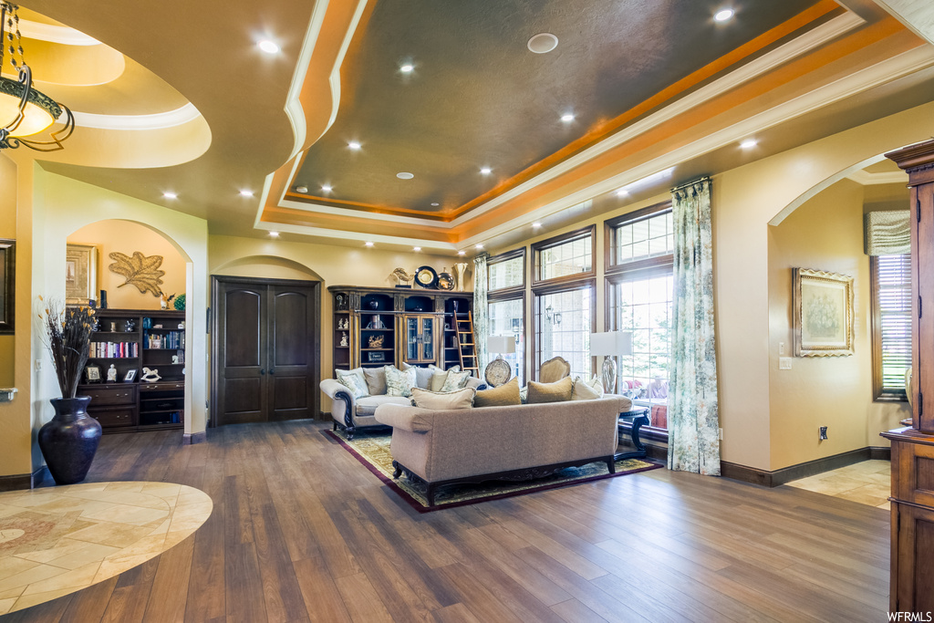 Hardwood floored living room with a raised ceiling
