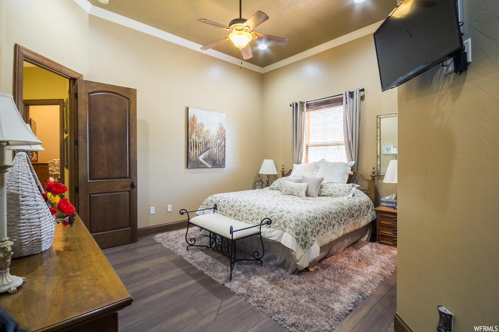 Hardwood floored bedroom featuring crown molding and ceiling fan
