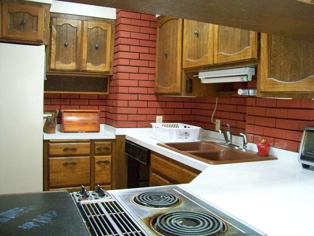 Kitchen featuring white fridge, backsplash, and black dishwasher
