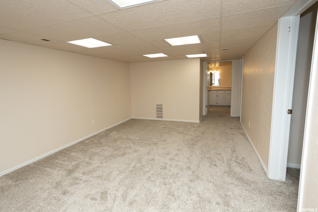 Carpeted empty room featuring a drop ceiling