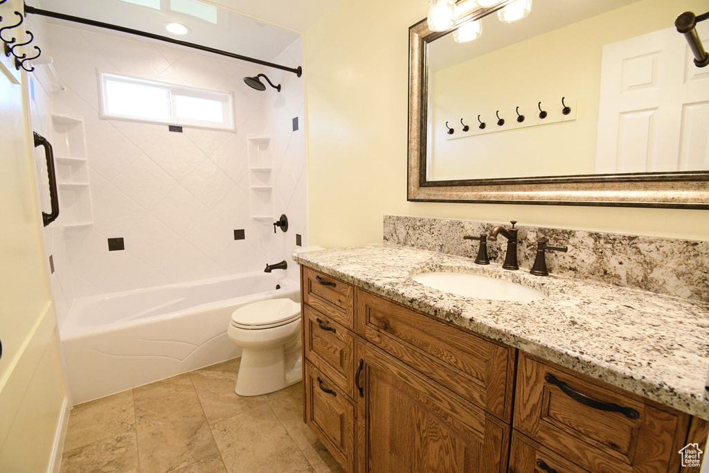 Full bathroom featuring tile floors, toilet, tiled shower / bath combo, and vanity